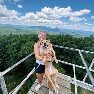 Team member with dog on mountain top overlook